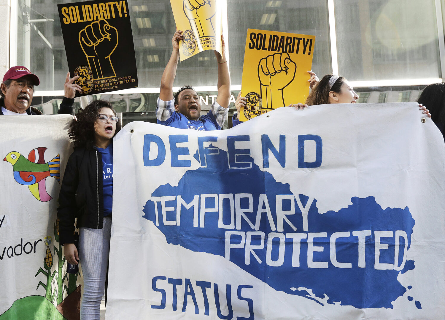 FILE - Supporters of temporary protected status immigrants hold signs and cheer at a rally before a...