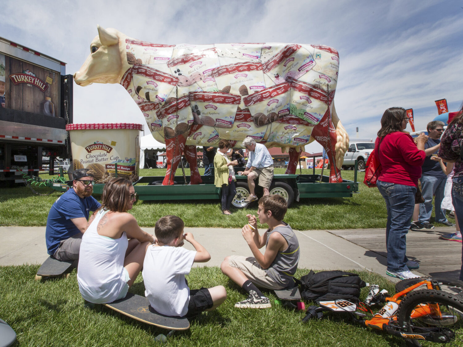 FILE - The giant Turkey Hill Cow looms over festival goers sampling ice cream at Taste of Omaha on ...