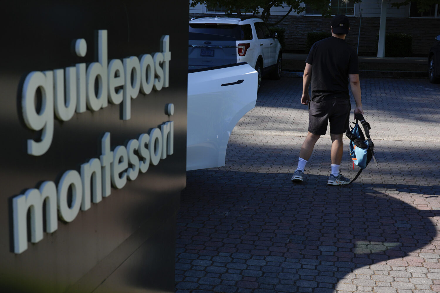 A guardian drops off a child at the Guidepost Montessori school on Friday, July 18, 2025, in Beaver...