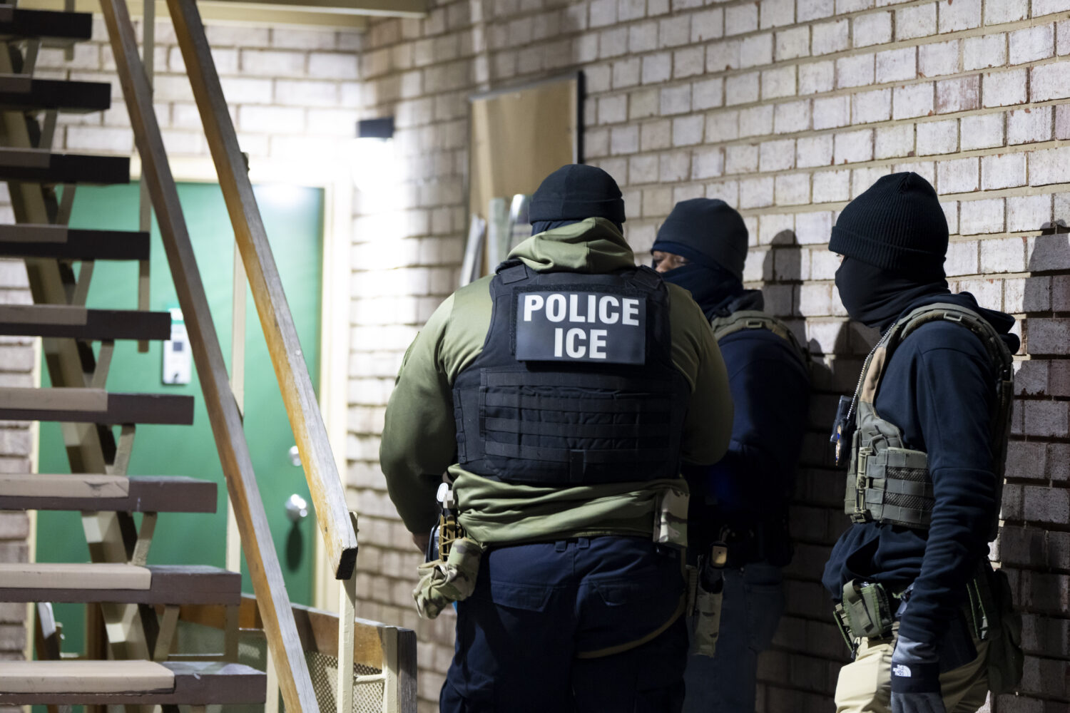 FILE - U.S. Immigration and Customs Enforcement officers wait to detain a person, Jan. 27, 2025, in...