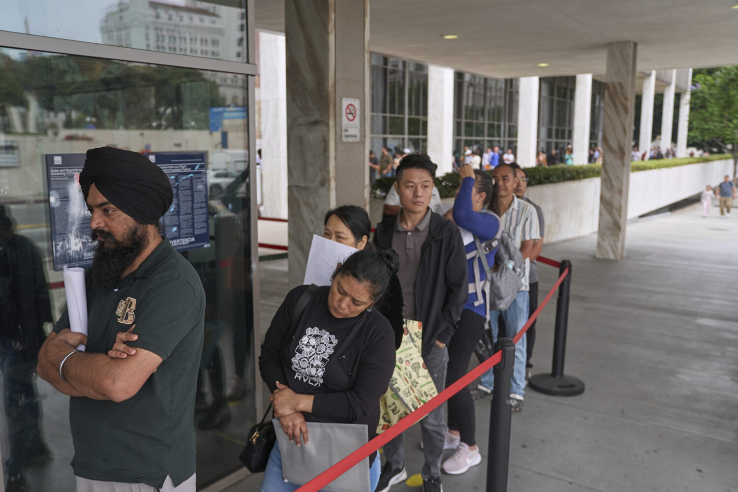 People line up outside the Los Angeles Federal Building in Los Angeles, housing the U.S. Immigratio...