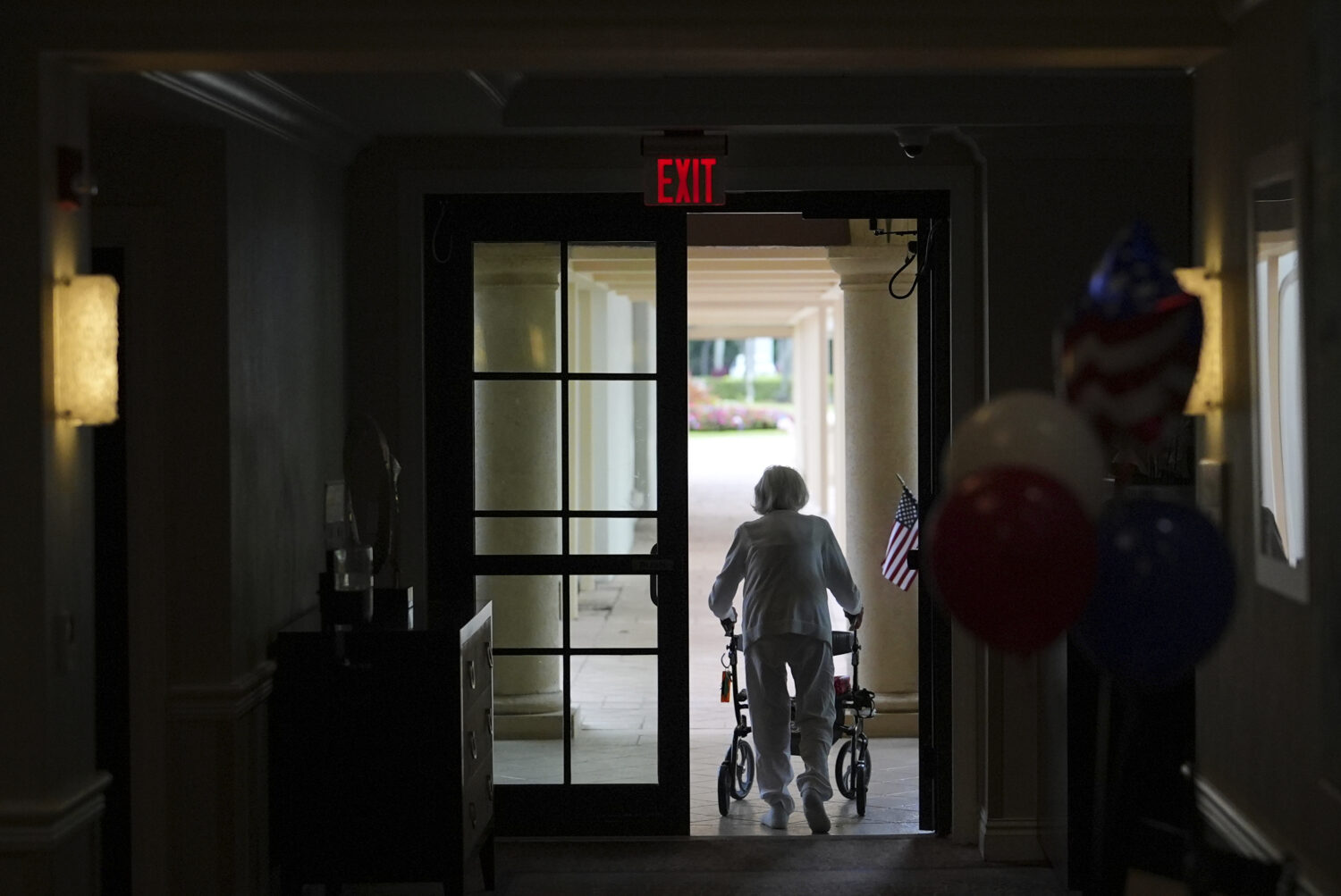 A woman uses a walker as she exits an assisted living building at the Toby and Leon Cooperman Sinai...
