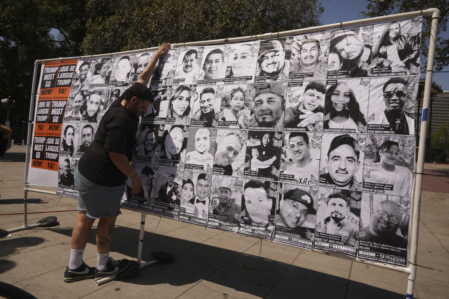 A volunteer sets up an art installation displaying names and faces of people who have been detained...