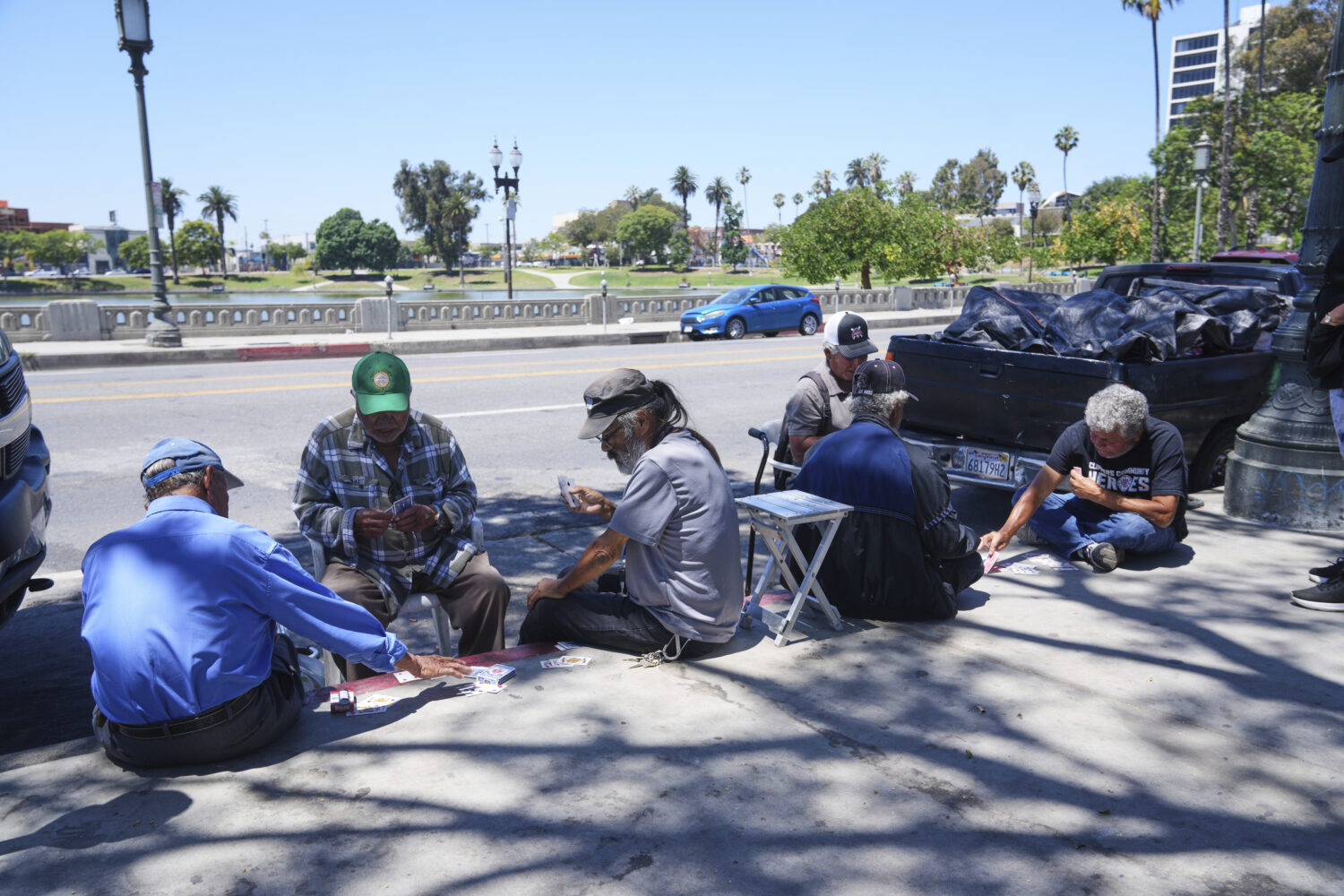 People play cards on a sidewalk at MacArthur Park, Tuesday, July 8, 2025, in Los Angeles. (AP Photo...
