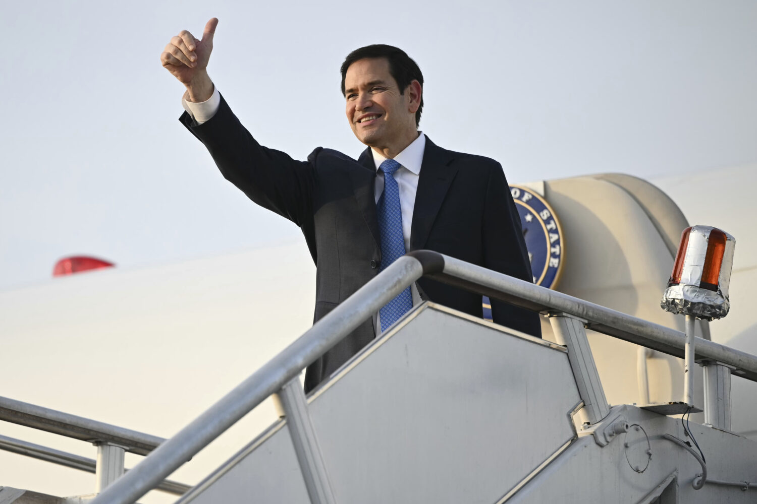 US Secretary of State Marco Rubio gestures as he boards his flight before departing from Subang Air...