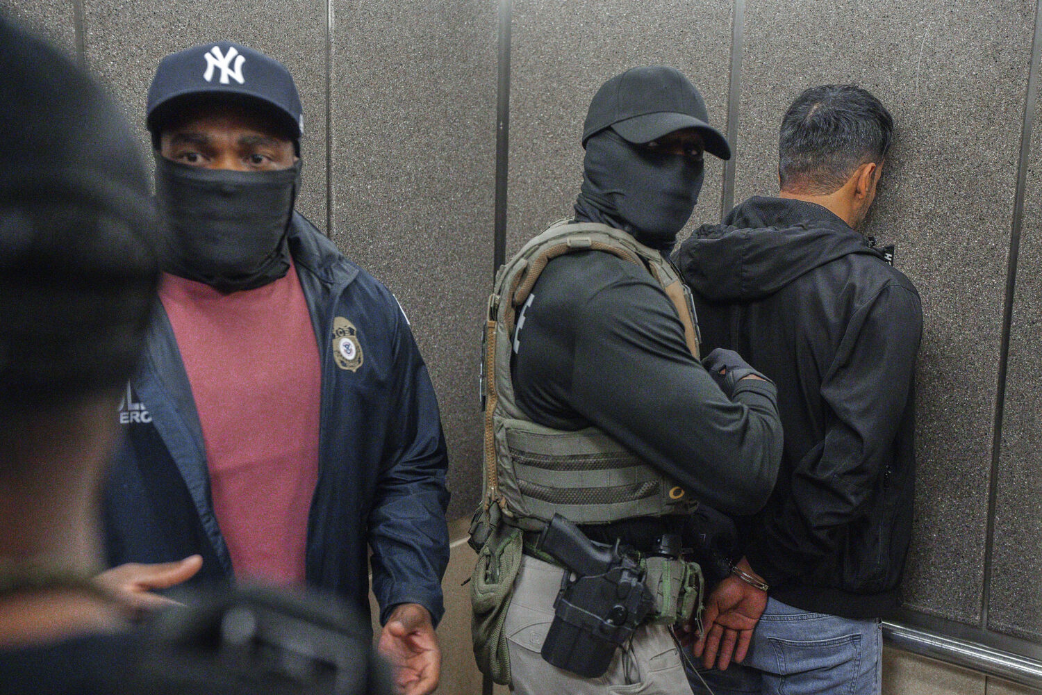 FILE - Immigration and Customs Enforcement agents escort a detained immigrant into an elevator afte...