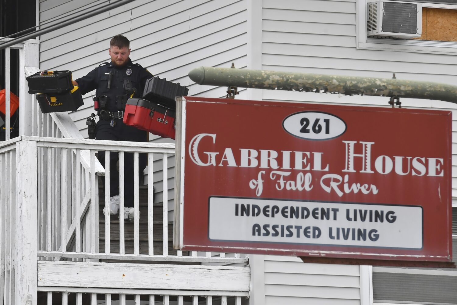 A law enforcement official removes boxes containing patient medications from the Gabriel House assi...