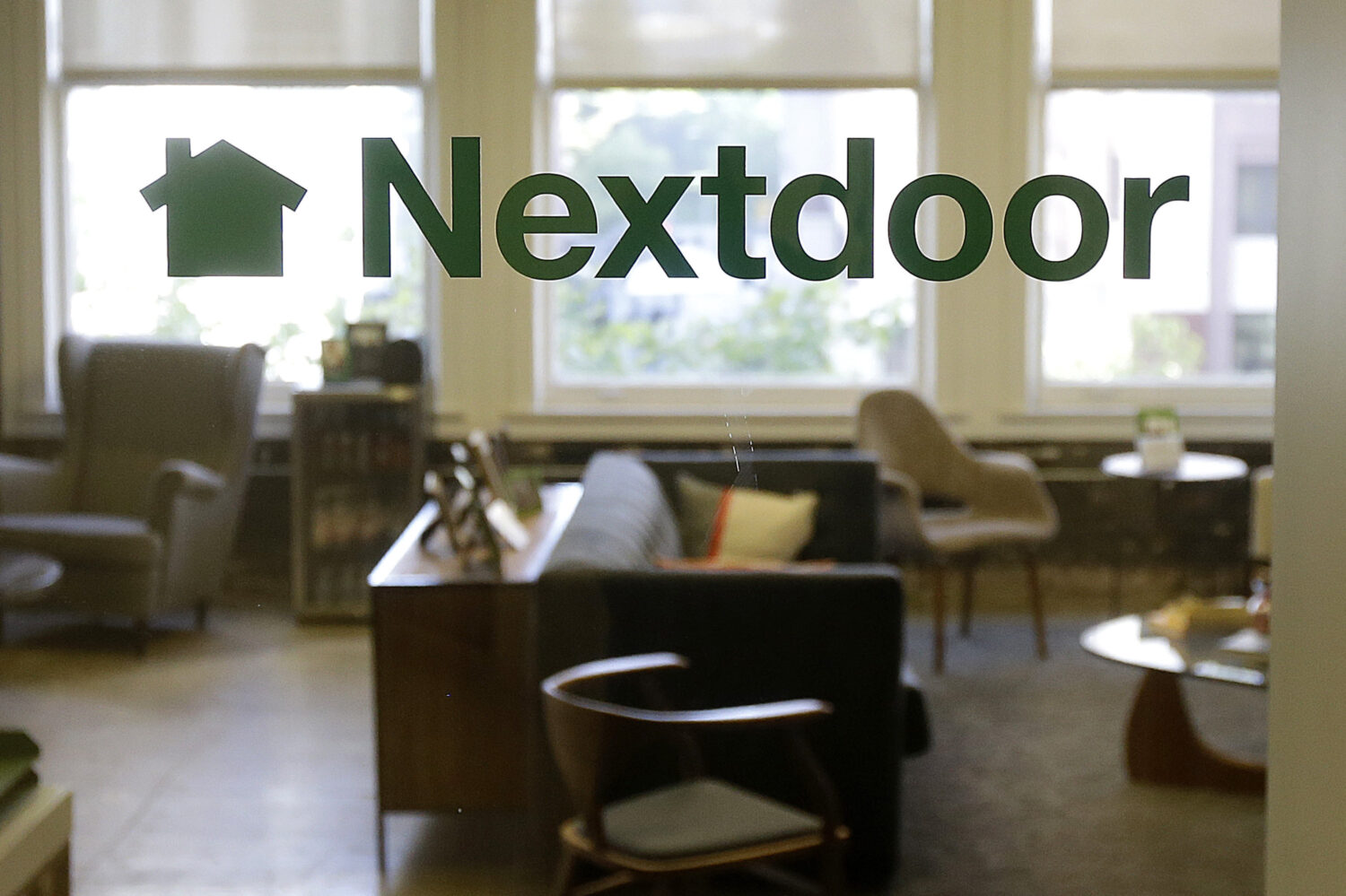 FILE - A Nextdoor sign is shown on a window at an office in San Francisco on May 11, 2016. (AP Phot...
