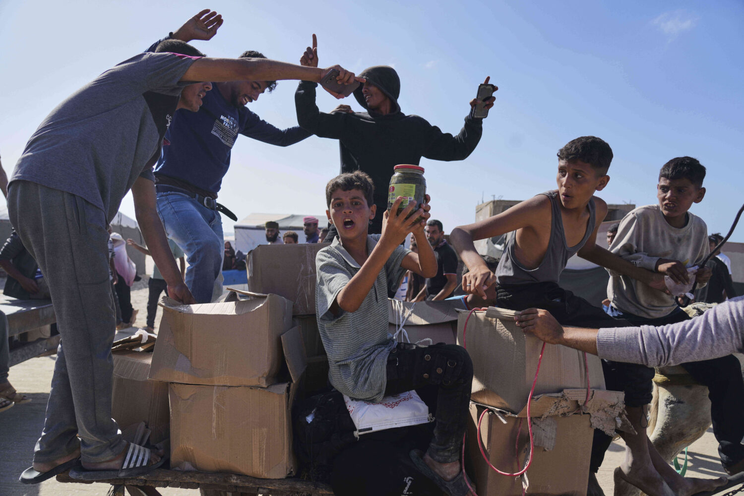 FILE - Palestinians carry boxes containing food and humanitarian aid packages delivered by the Gaza...