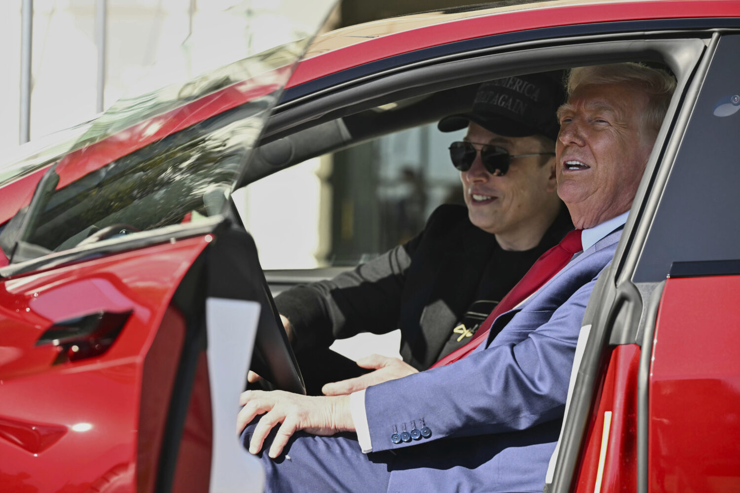 FILE - President Donald Trump and Tesla CEO Elon Musk speak to reporters as they sit in a red Model...