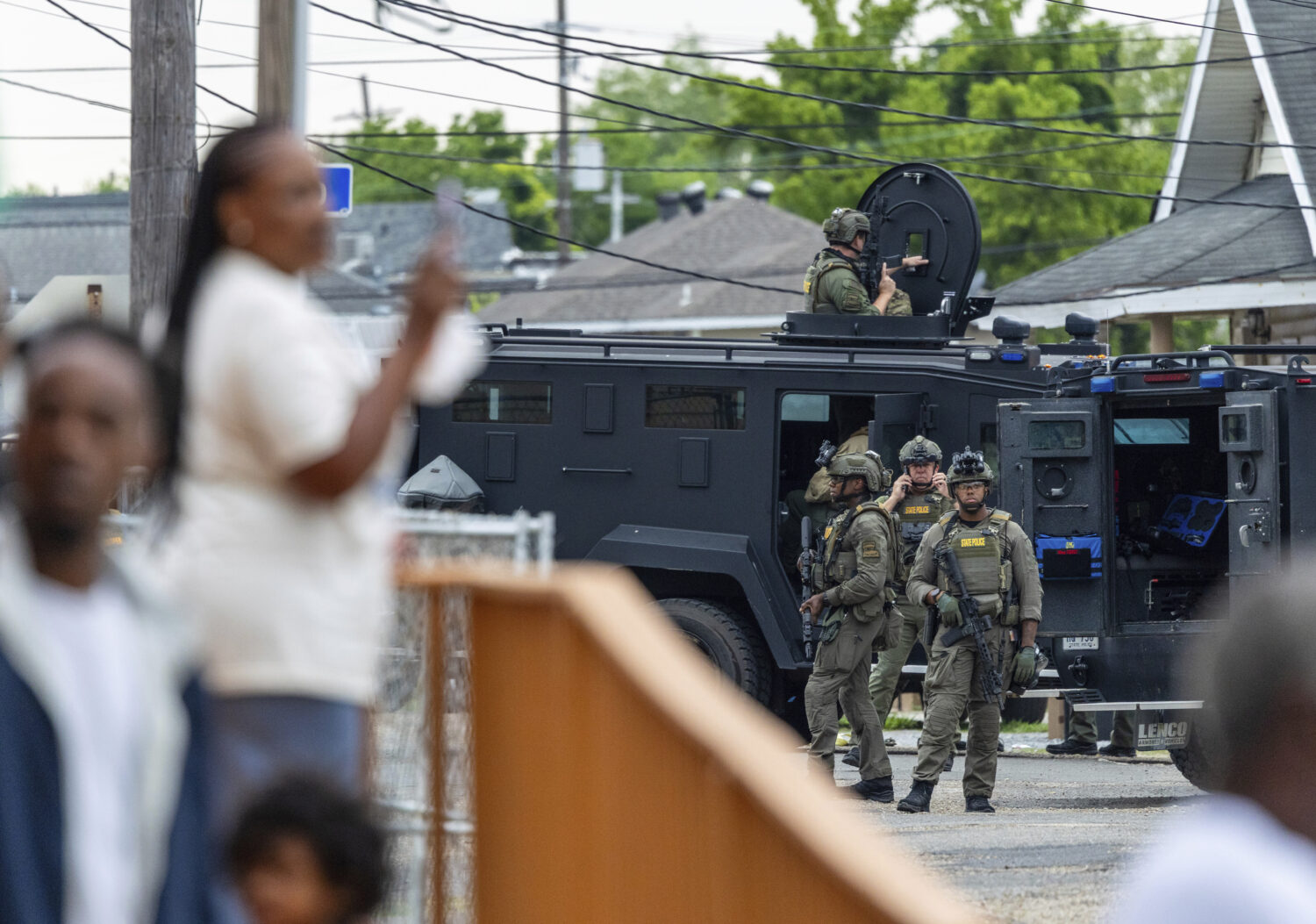 FILE - Residents watch as law enforcement search for a fugitive that escaped a prison in New Orlean...