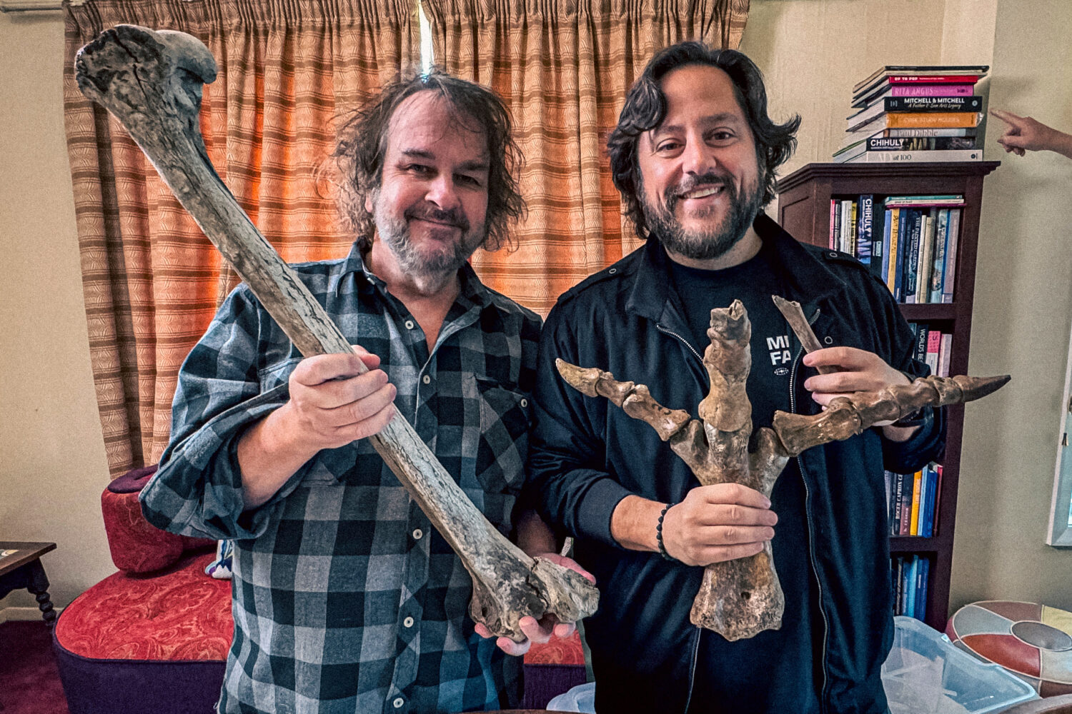 Filmmaker Peter Jackson, left, and Colossal CEO Ben Lamm hold up bones from Jackson's collection of...