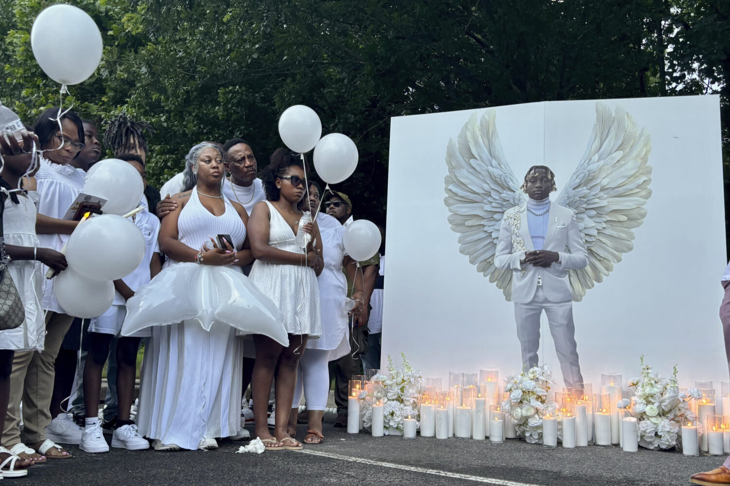 Family members of Jabari Peoples hold balloons at a candlelight vigil in Homewood, Ala., Monday, Ju...