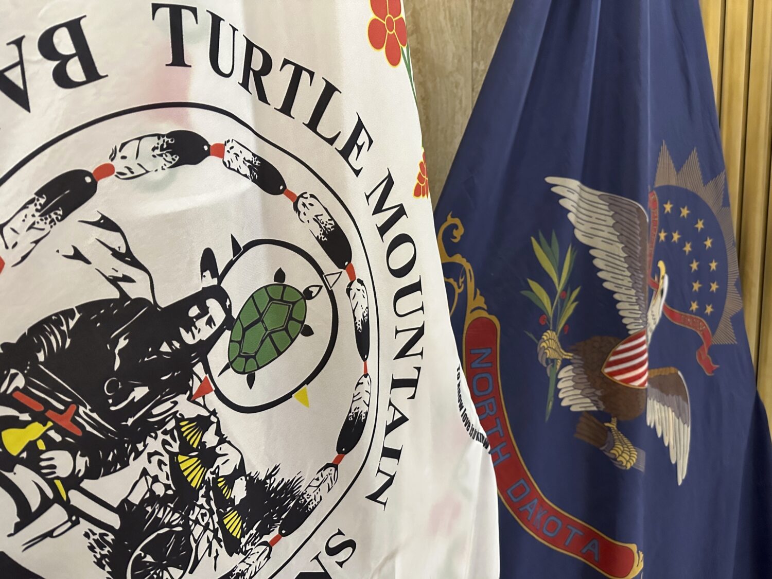 FILE - Flags for the Turtle Mountain Band of Chippewa Indians and the state of North Dakota stand i...
