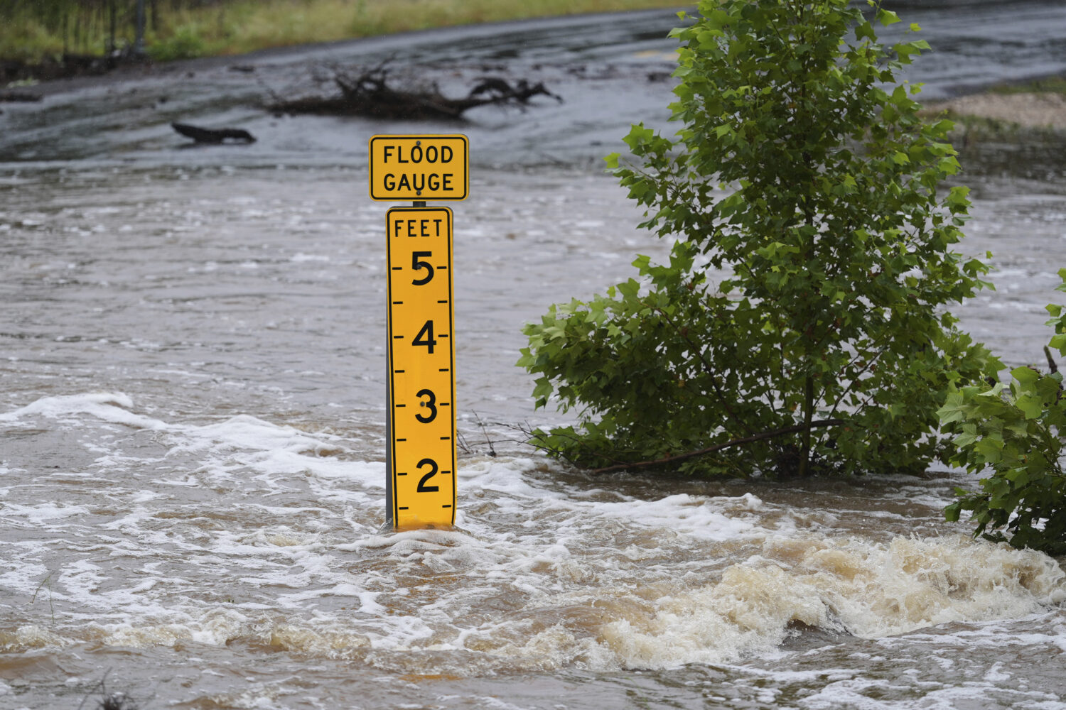 A flood gauge marks the height of water flowing over a farm-to-market road near Kerrville, Texas, o...