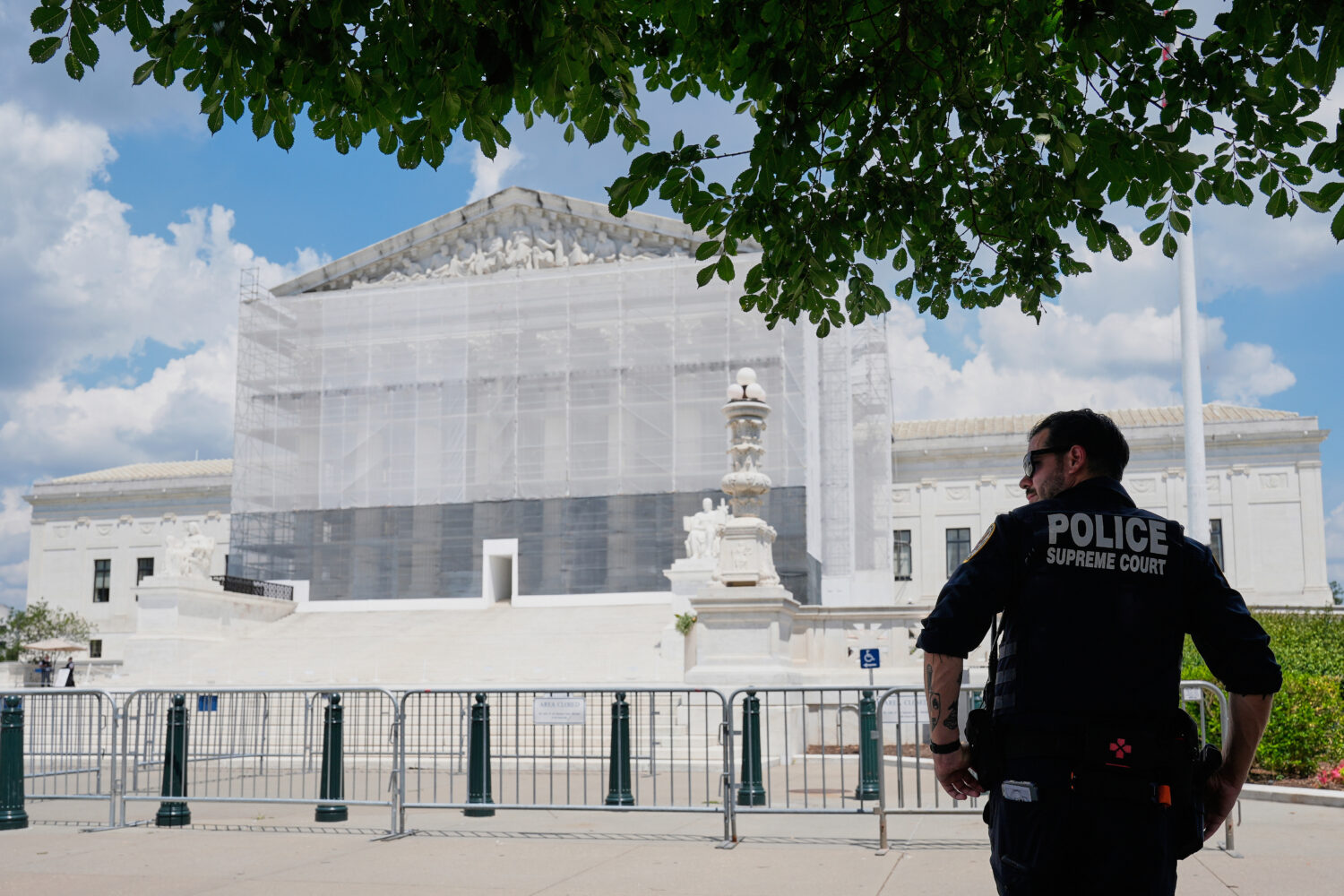 A U.S. Supreme Court police officer stands watch as anti-abortion protesters rally outside of the S...