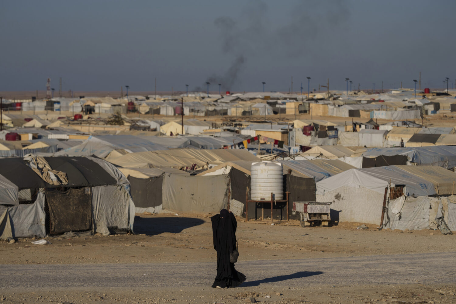 FILE - A woman walks in the al-Hol camp in northeastern Syria's Hasakeh province, where tens of tho...