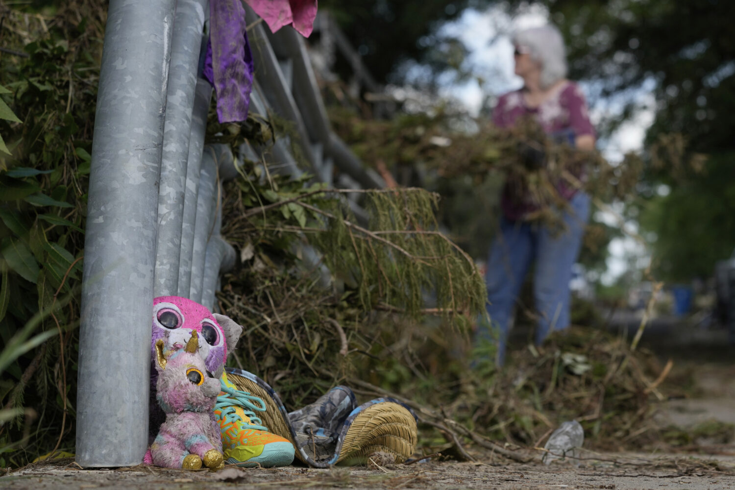 Lost items sit at a bridge as a volunteer cleans up debris on Tuesday, July 8, 2025, after a flash ...