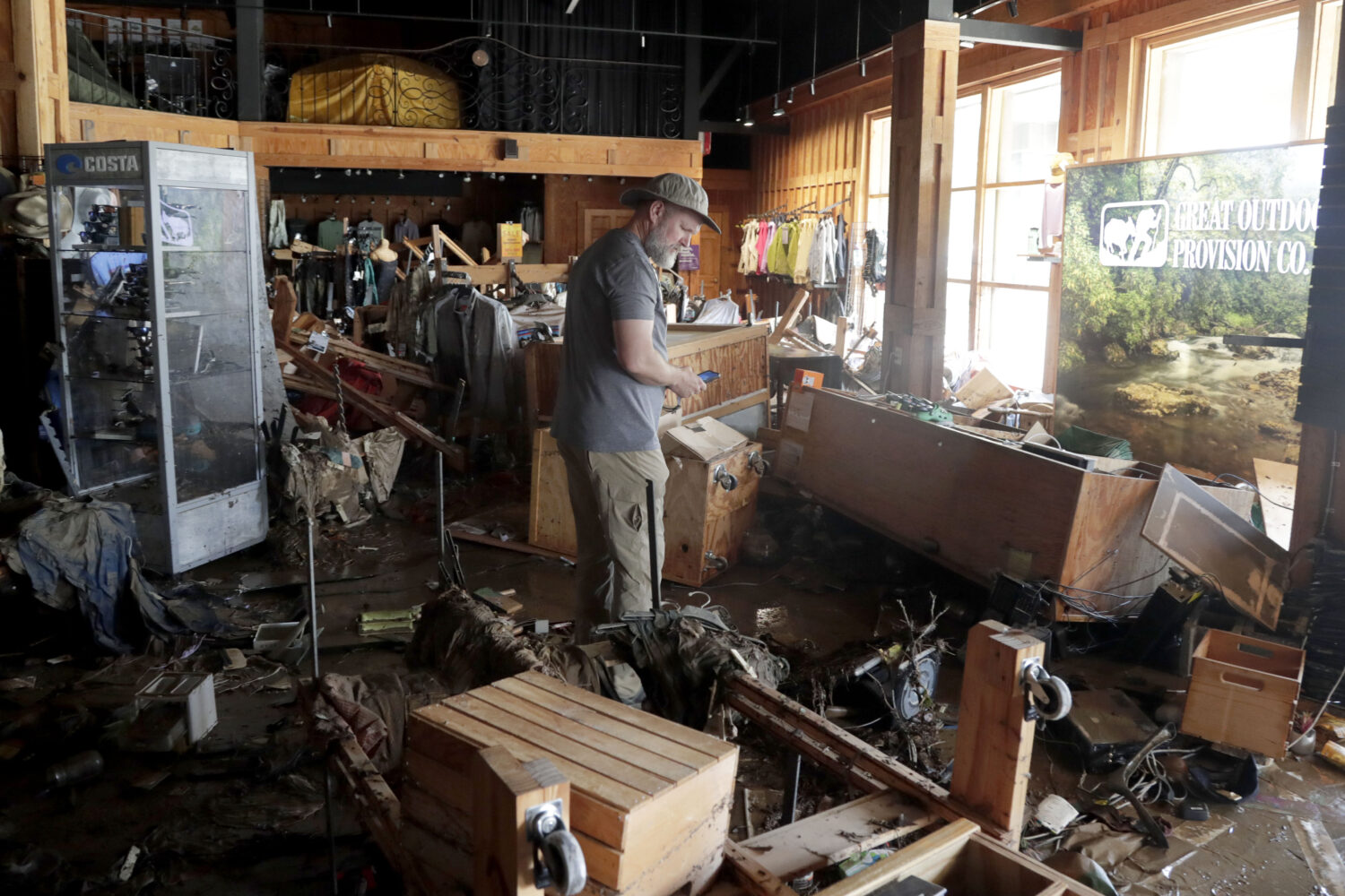 An employee surveys the damage at the Great Outdoor Provision Co. after it was flooded during tropi...