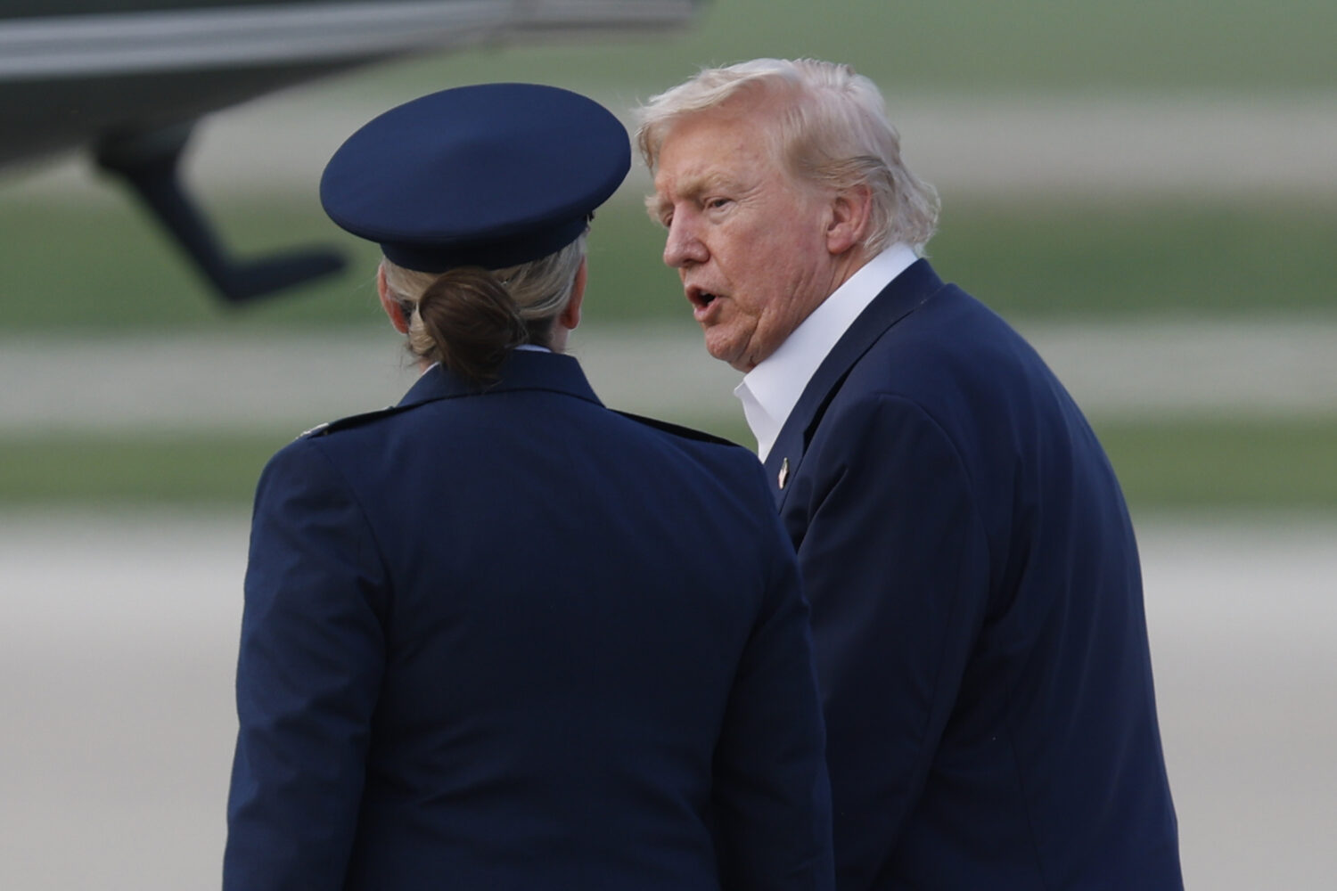 President Donald Trump, right, is escorted by Air Force 89th Air Wing Deputy Commander Melissa Domb...
