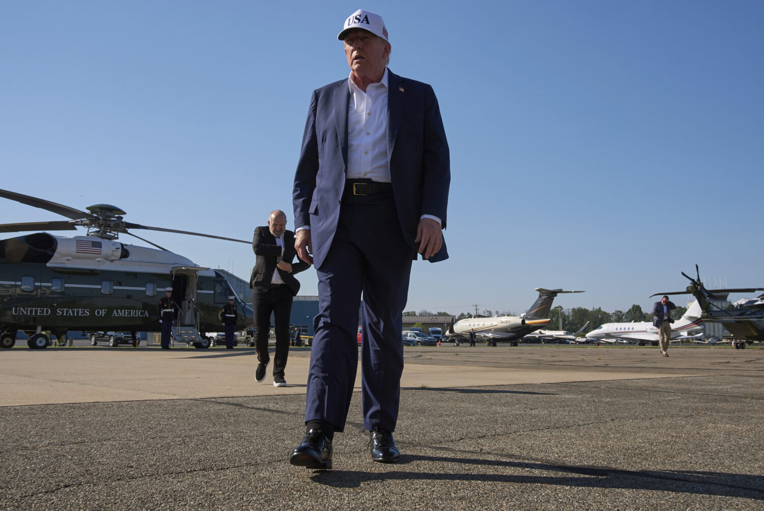 President Donald Trump walks toward the media to speak with them before boarding Air Force One, at ...