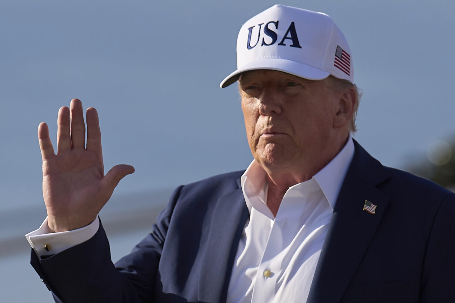 President Donald Trump waves to the media after exiting Air Force One, at Joint Base Andrews, Md., ...
