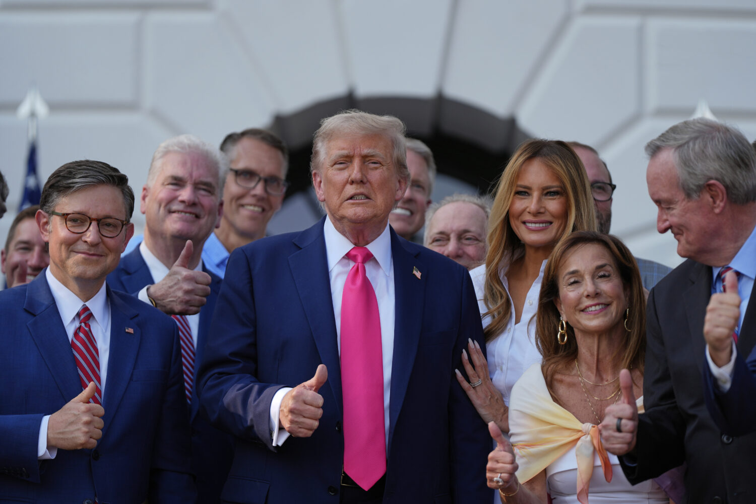 President Donald Trump poses for a photo after signing his signature bill of tax breaks and spendin...