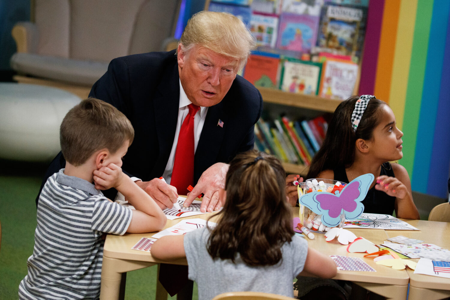 FILE - President Donald Trump colors during a visit with a group of children at the Nationwide Chil...