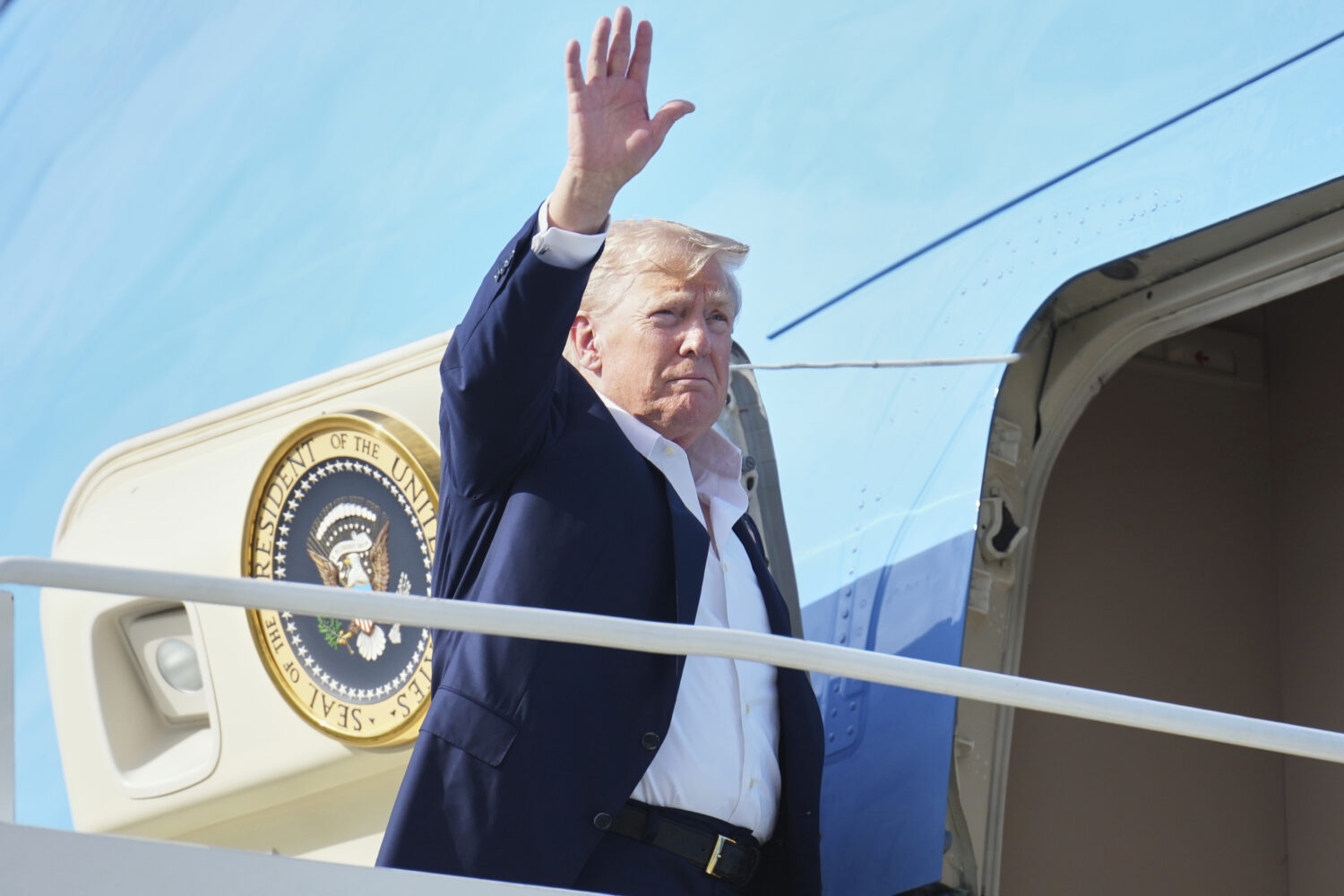 President Donald Trump waves as he boards Air Force One, Tuesday, July 29, 2025, at Royal Air Force...
