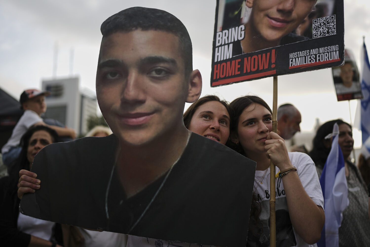 FILE - People watch a live broadcast of Israeli-American soldier Edan Alexander as he is released f...