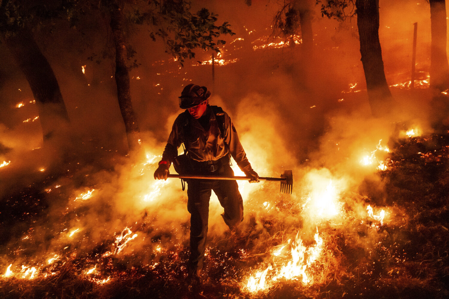 A firefighter battles the Pickett Fire burning in the Aetna Springs area of Napa County, Calif., on...