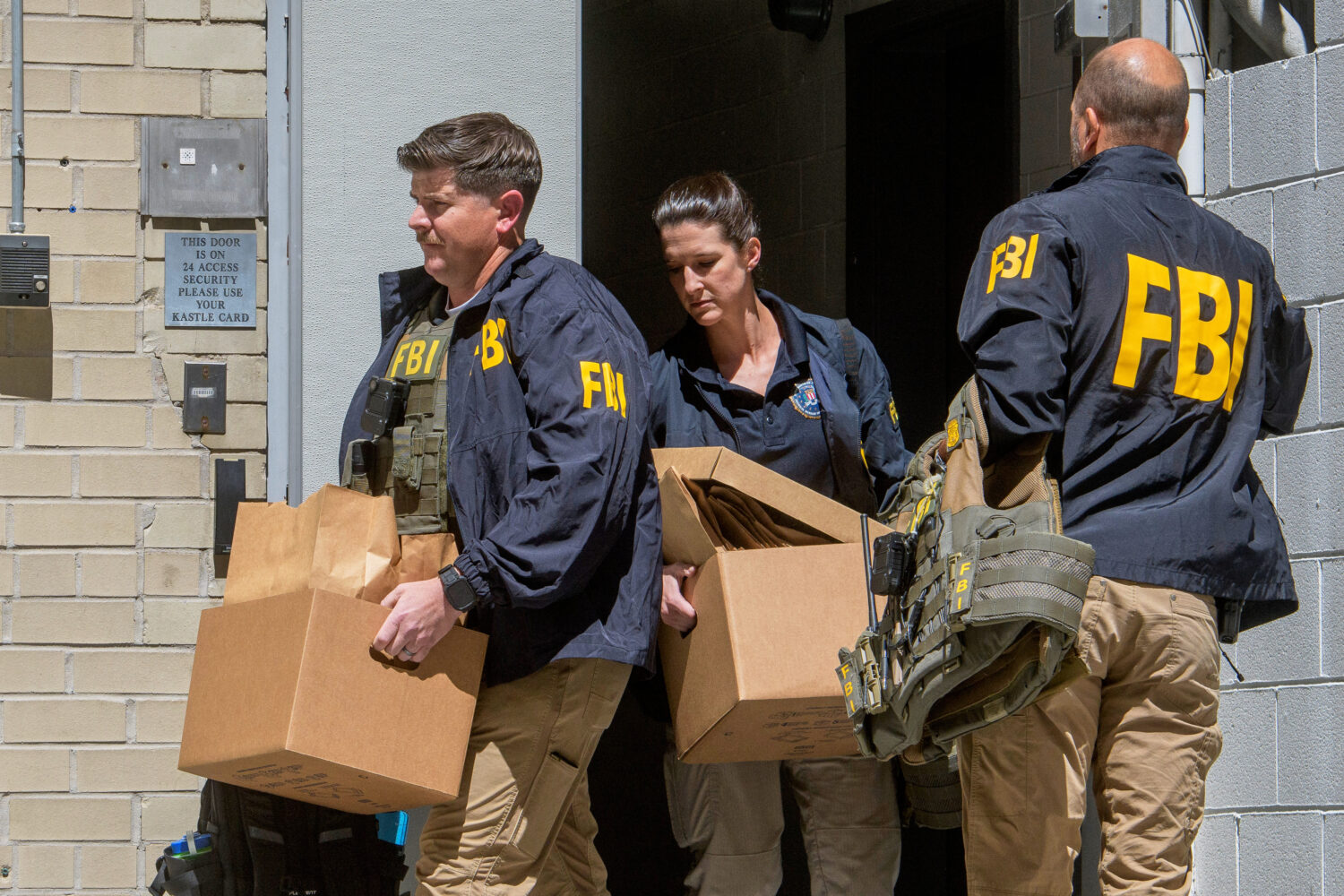 FBI agents carry boxes from former National Security Advisor John Bolton's office in Washington, Fr...