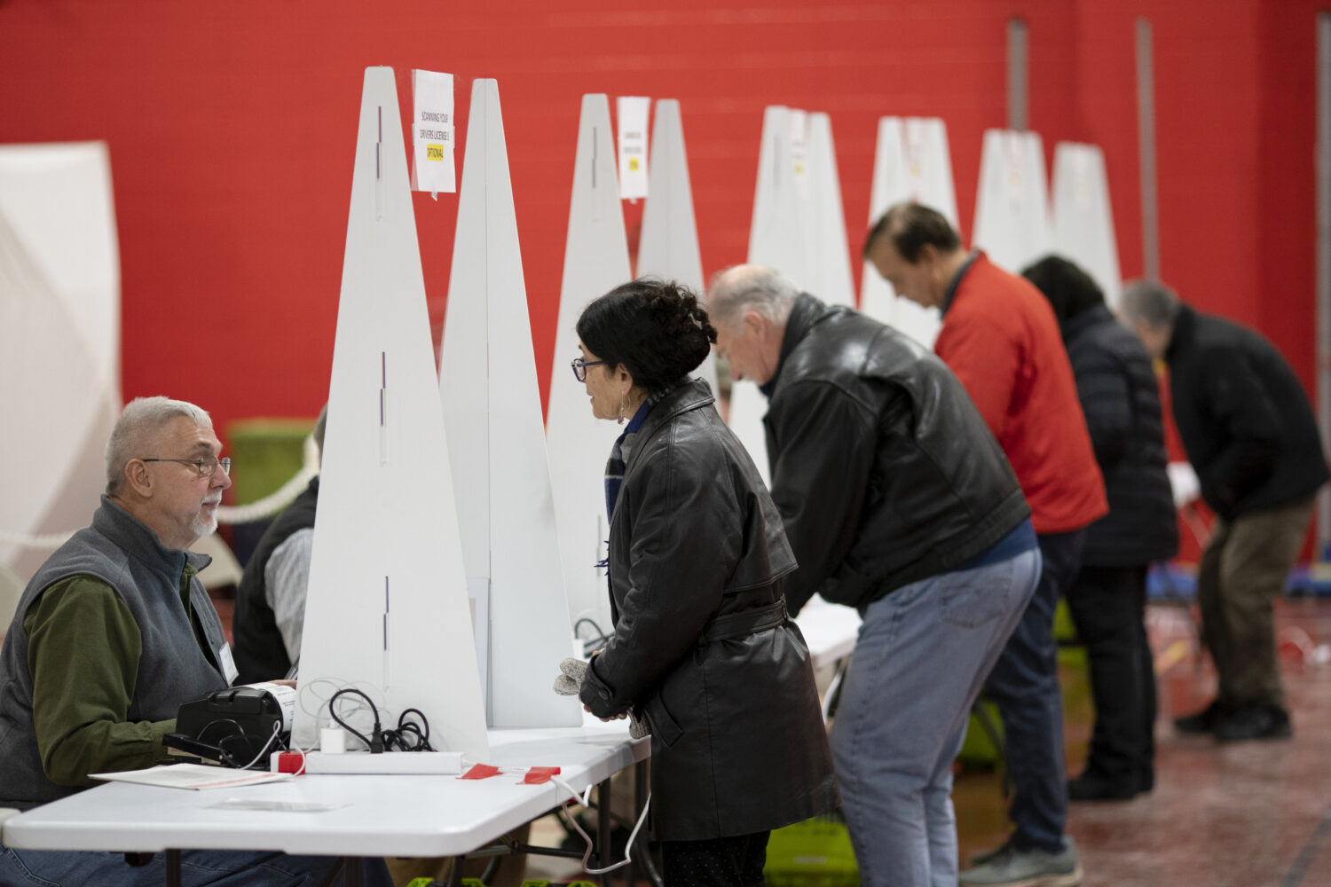 FILE - Voters check in to cast ballots in the New Hampshire presidential primary at a polling site ...