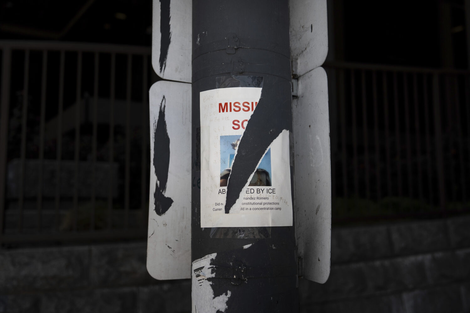 A torn missing person flyer, for an immigrant believed to be detained by ICE, is posted on a pole i...
