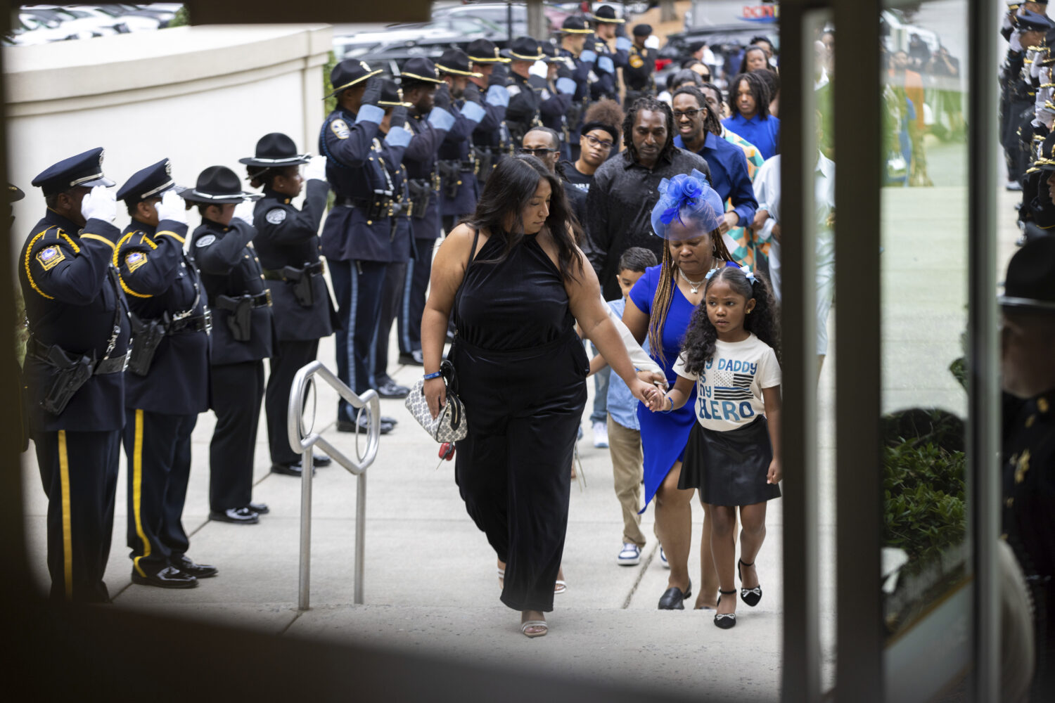 Family members, including DeKalb County Police Officer David Rose's daughter, right, arrive at Firs...