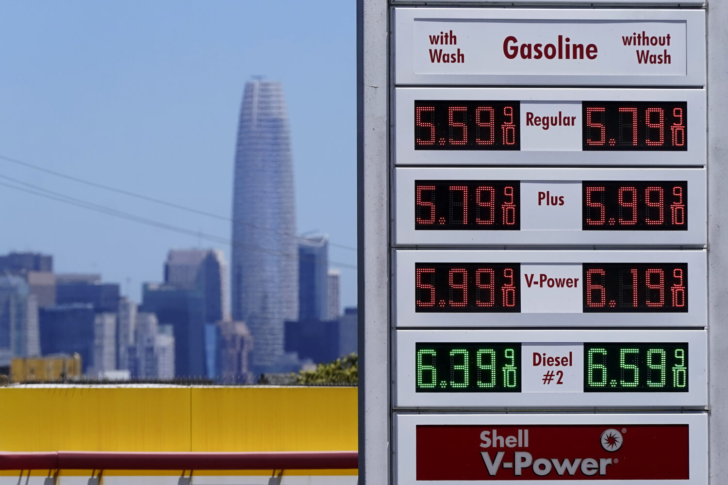 FILE - The Salesforce Tower and skyline are shown behind the gasoline price board at a gas station ...