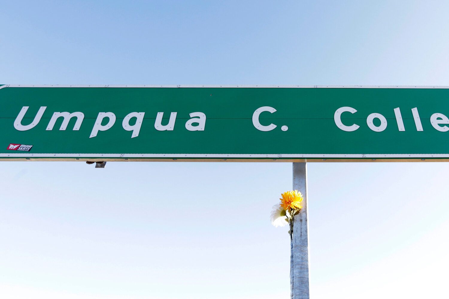 FILE - A flower is posted on a direction sign to Umpqua Community College, Oct. 2, 2015, in Rosebur...