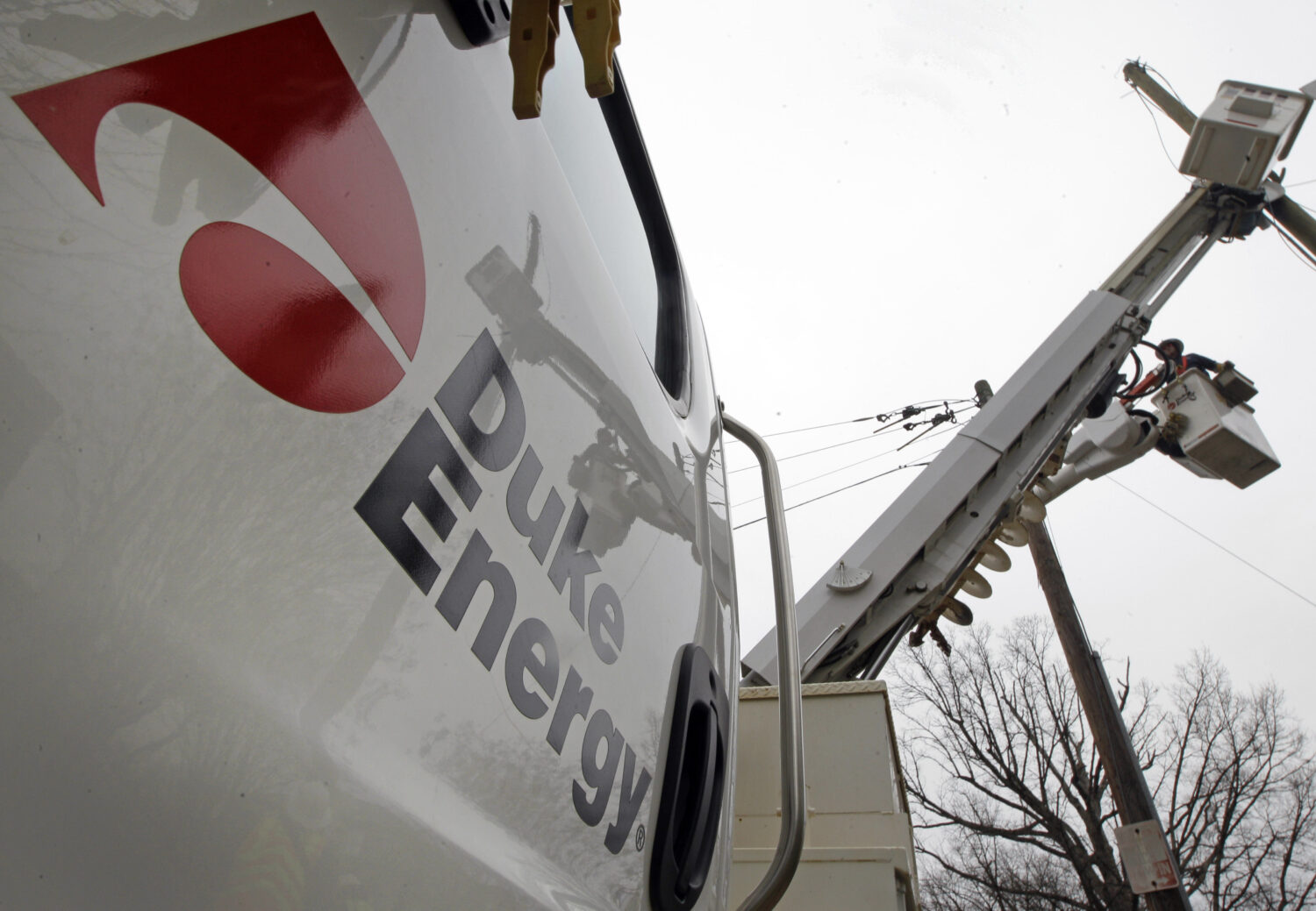 FILE - Duke Energy employees work on power lines in Charlotte, N.C., Feb. 14, 2012. (AP Photo/Chuck...