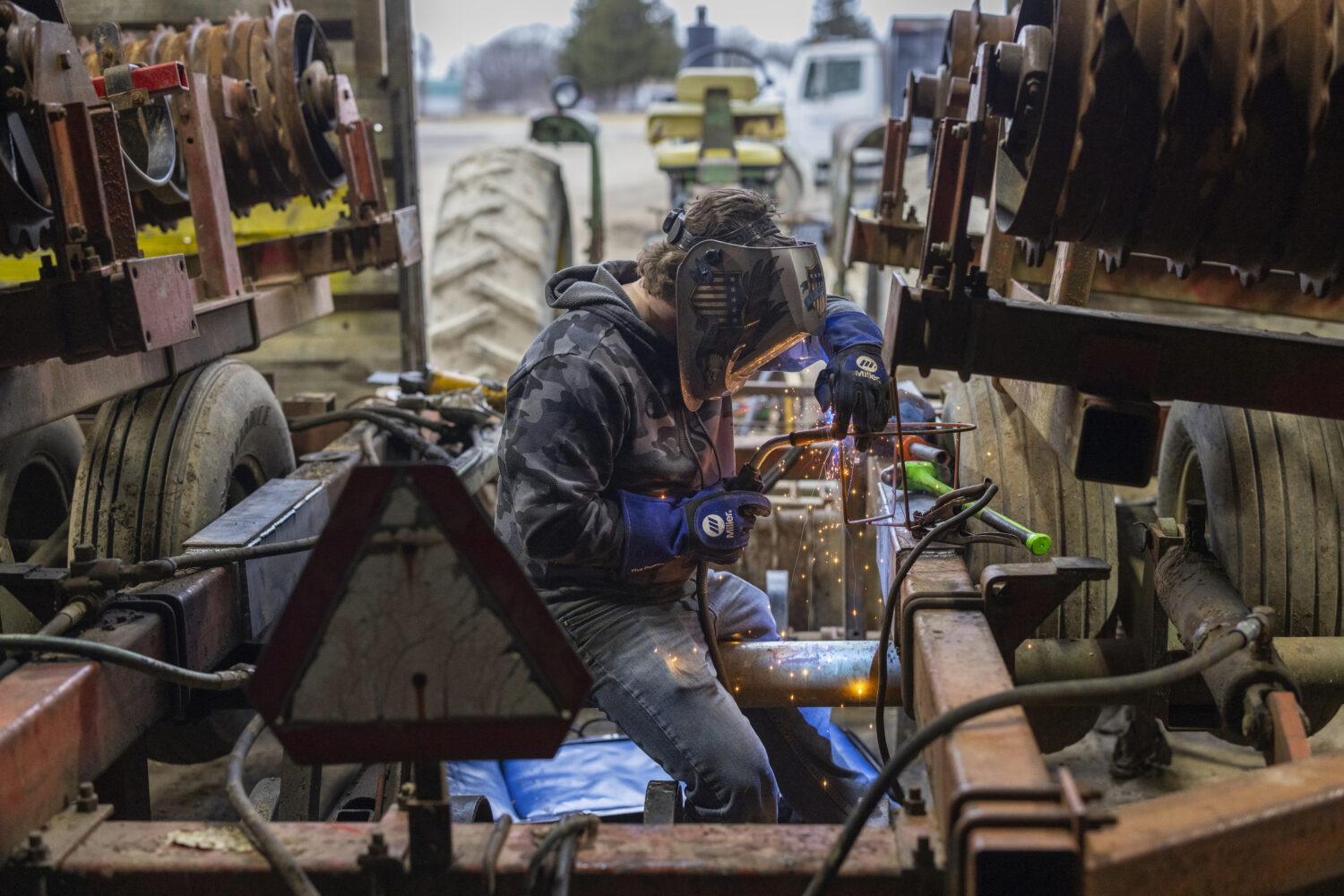 Devon Wells, a junior at Perry Central High School, welds a metal calf feeder at Halo Farms, where ...