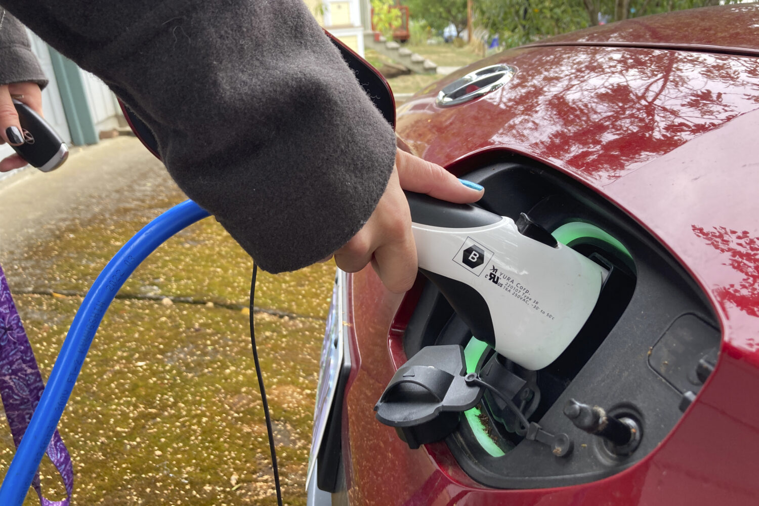 FILE - Rebecca DeWhitt charges her electric vehicle on Sept. 30, 2022, in the driveway of the Portl...