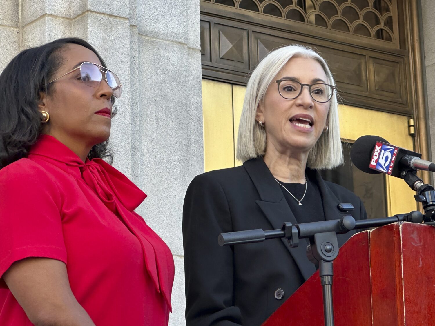 Fulton County Commissioner Dana Barrett (right) speaks outside the Fulton County courthouse in Atla...