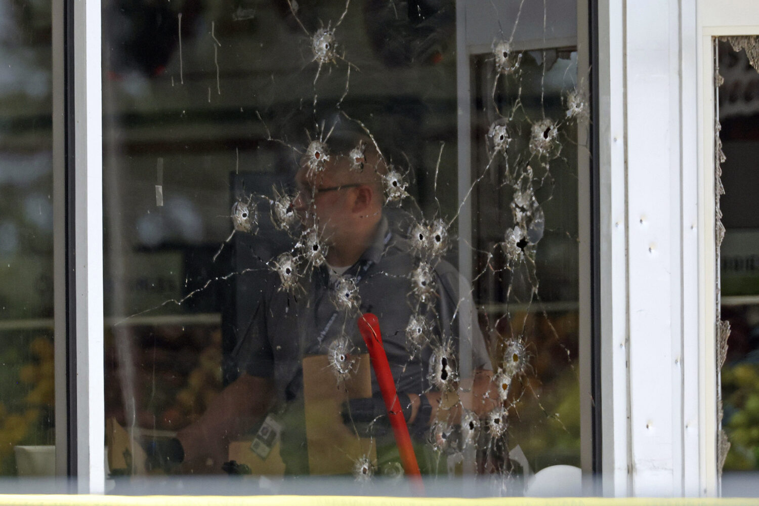 FILE - Damage can be seen to a front window as law enforcement officers work the scene of a shootin...
