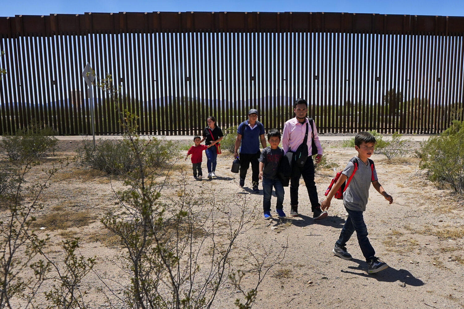 FILE - A family of five claiming to be from Guatemala and a man stating he was from Peru, in pink s...