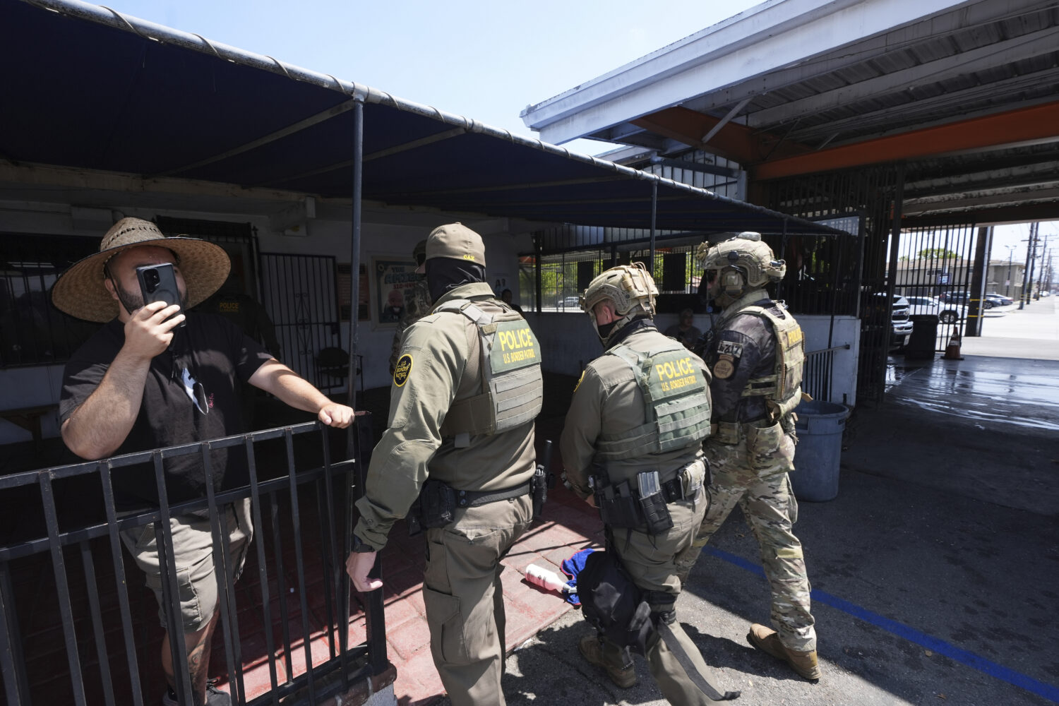 FILE - Immigration agents conduct an operation at a car wash, Aug. 15, 2025, in Montebello, Calif. ...