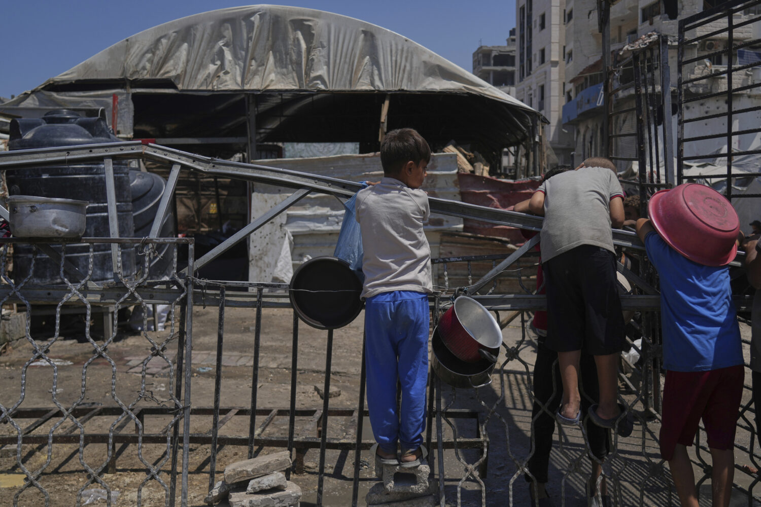 A Palestinian children wait at a community kitchen before donated food is prepared and distributed ...