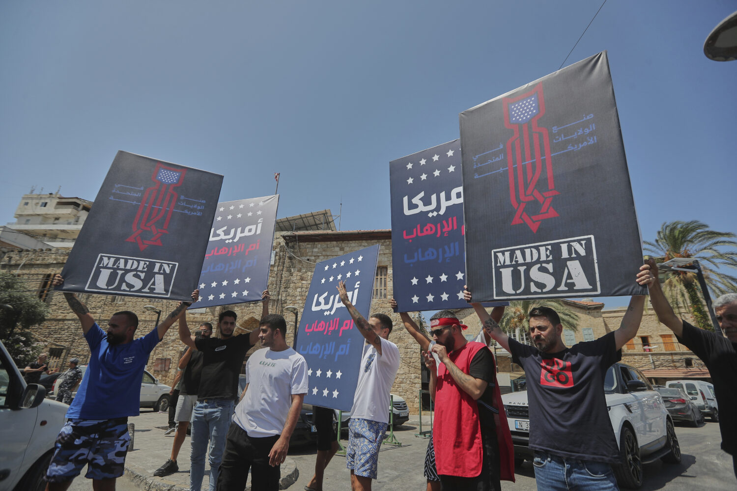 Shiite men hold up posters that read in Arabic: "America is the mother of terrorism", during a prot...