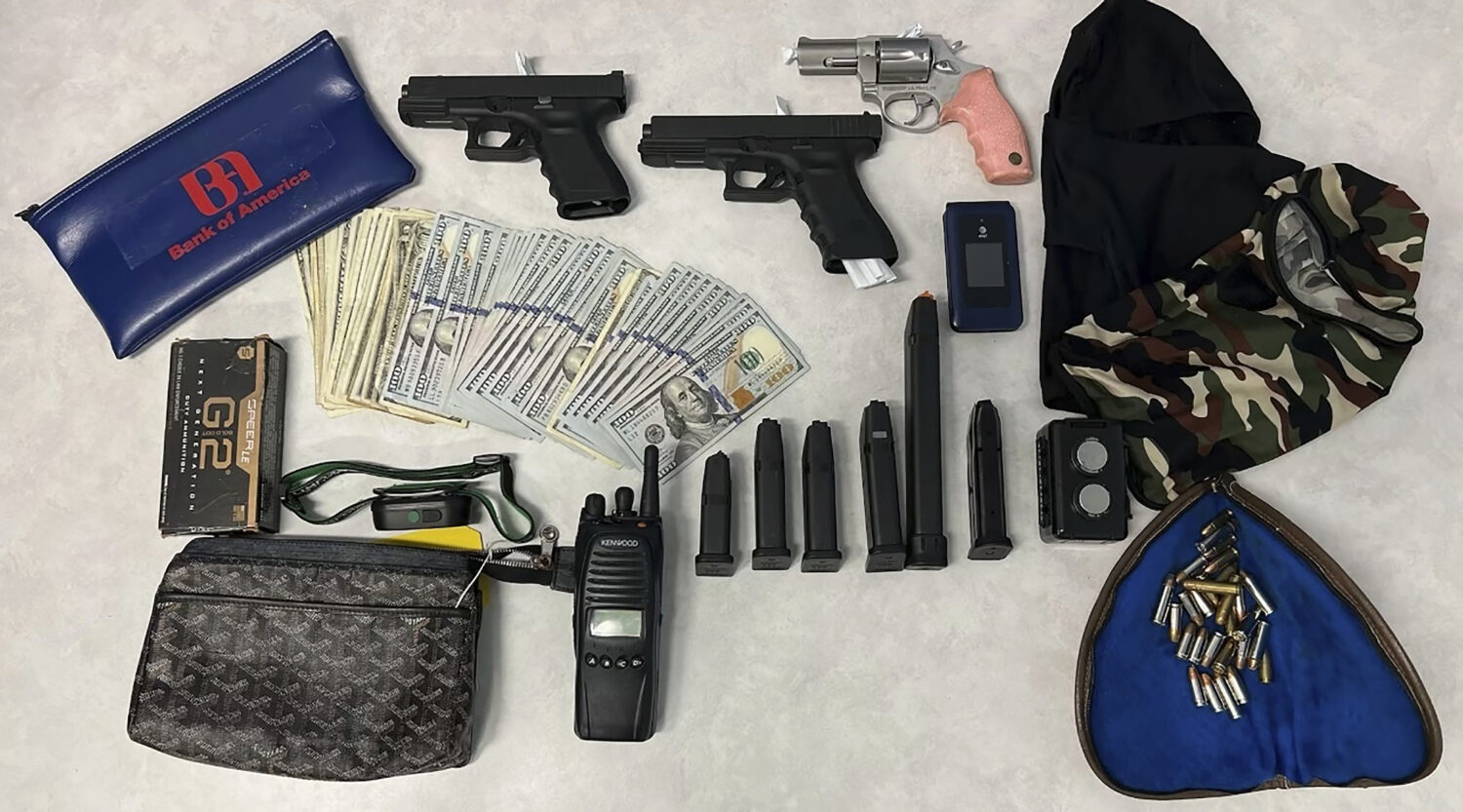 This undated photo provided by the Los Angeles Police Department shows firearms, cash, and stolen v...