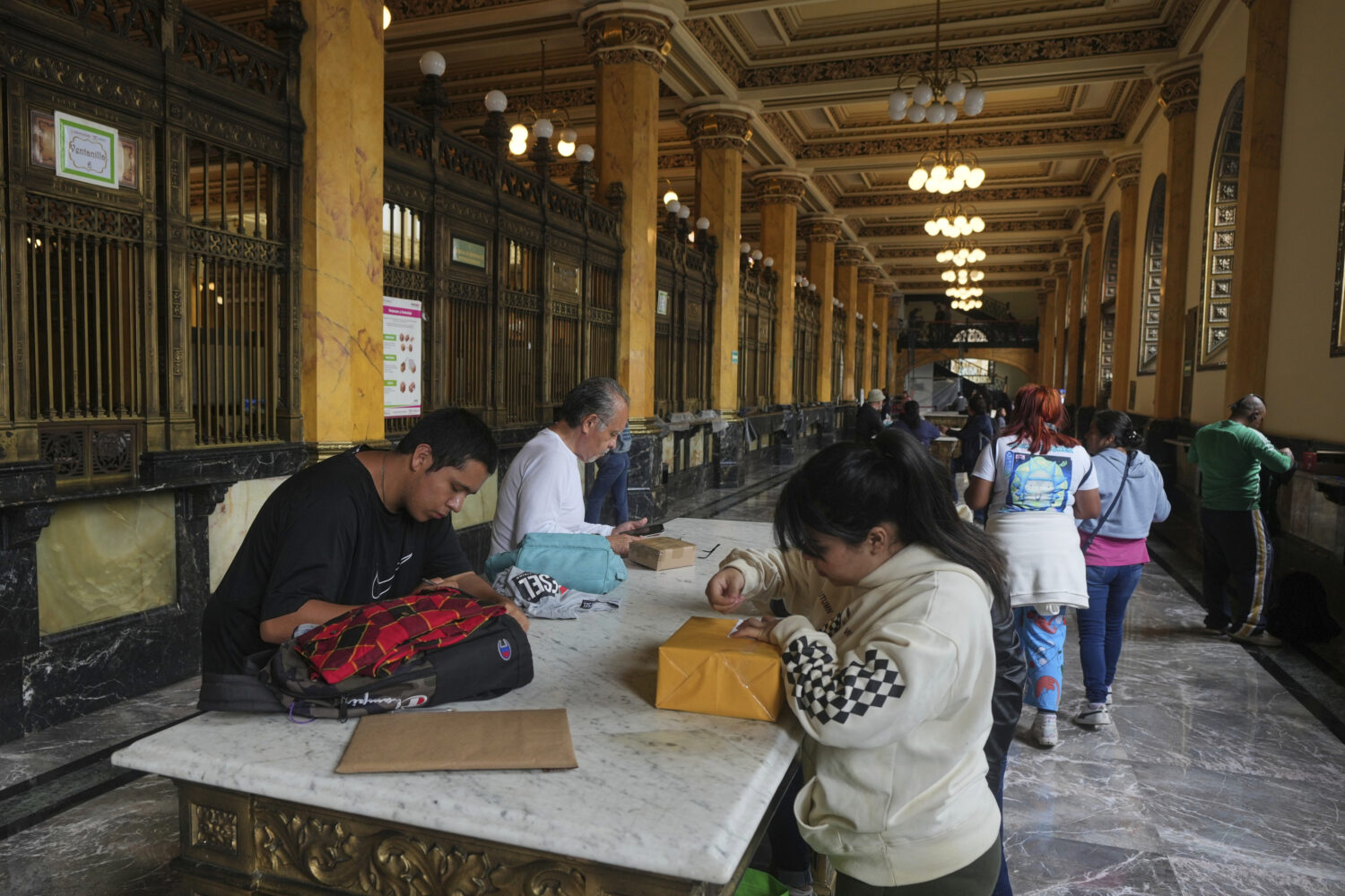People prepare packages to send at the Main Post Office in Mexico City, Wednesday, Aug. 27, 2025. (...