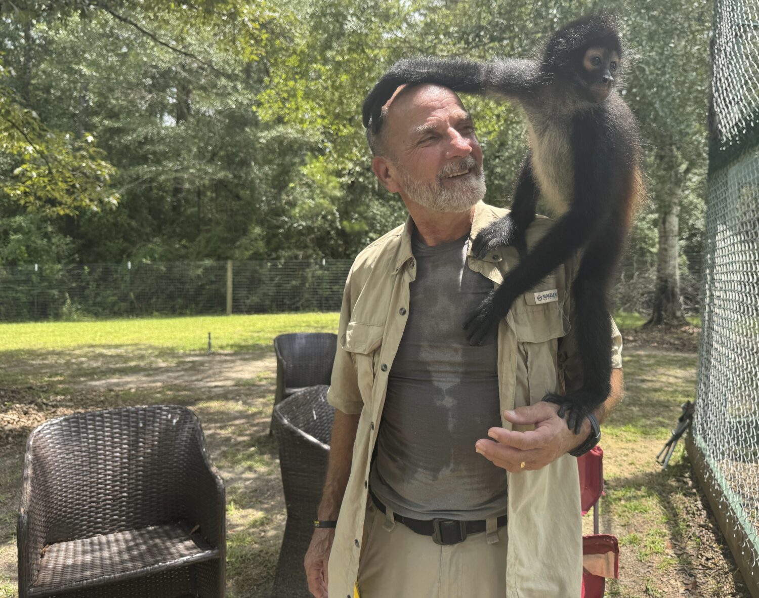 Louie the spider monkey climbs on John Richard, a volunteer at the Gulf Coast Primate Sanctuary in ...