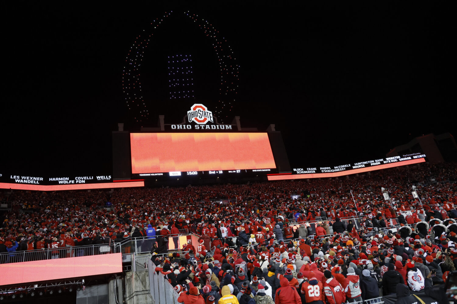 FILE - Fans watch a drone show displaying the CFP logo above Ohio Stadium during the second half in...